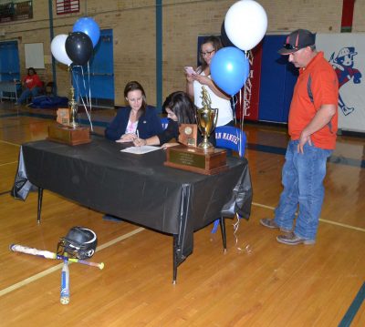 Dionne Ruiz signs her NLI while her parents (standing) and SMHS Athletic Director Melissa Joliat (seated) look on.