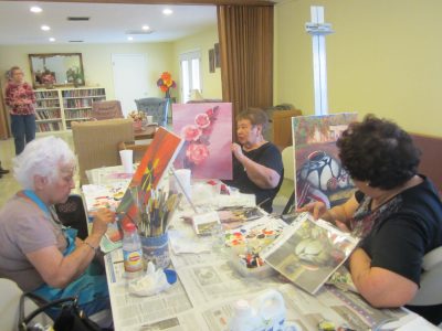 ArtUs Guild members (l to r) Cobina Martinez, Lina Cruz and Frankie Olmos put the finishing touches on the paintings they were working on last spring. The fall session begins Friday, Oct. 7 at Ray Hall. New members are welcome to check the group out beginning at 10 a.m. 