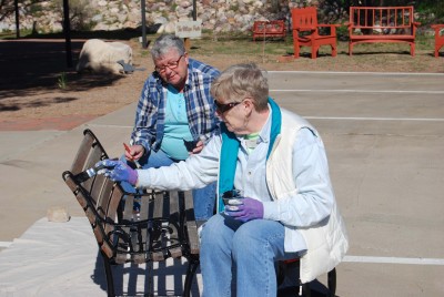 Virginia Bontz and Linda Tyas restoring a church bench.